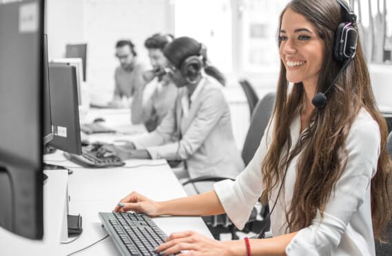 A female customer service highlighted with her three other colleges in the back.