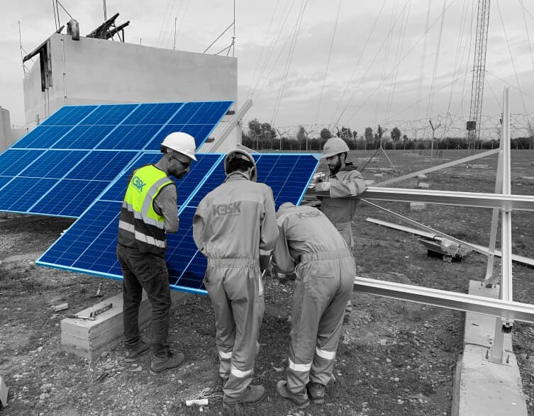 Team of engineers working on a solar panel on site.